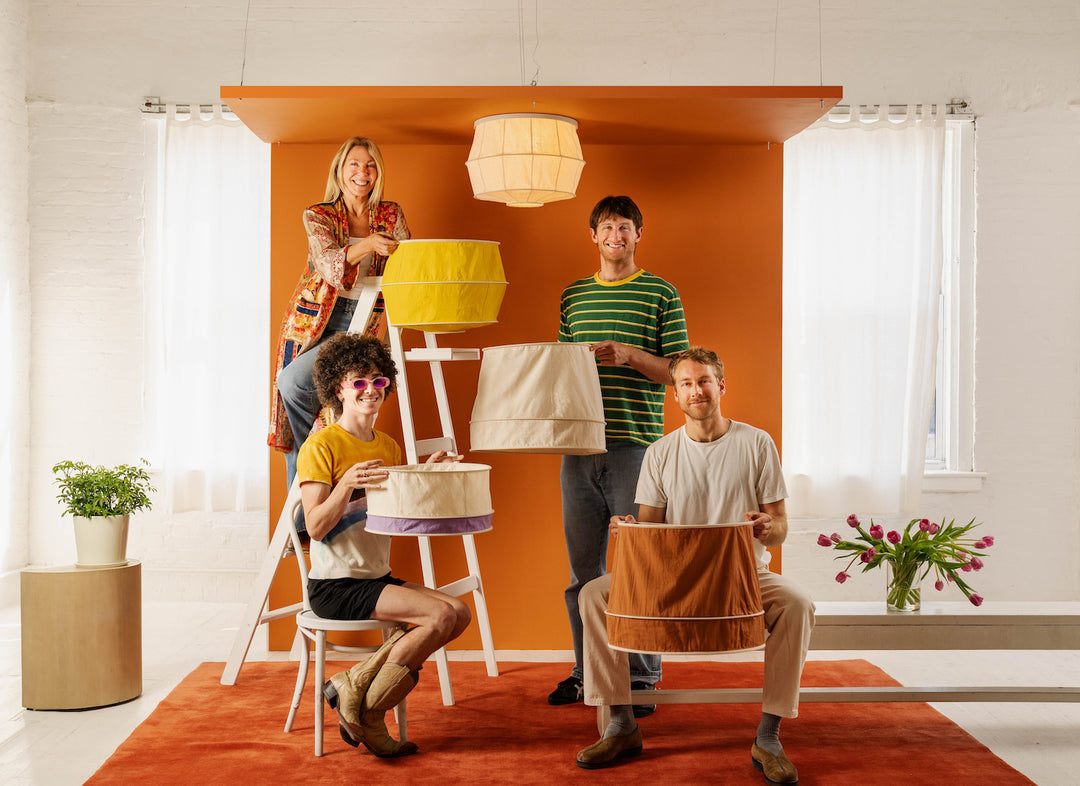 Four people holding different colored ceiling light cover replacements